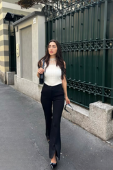 a lady wears a white tank top with black skinny jeans